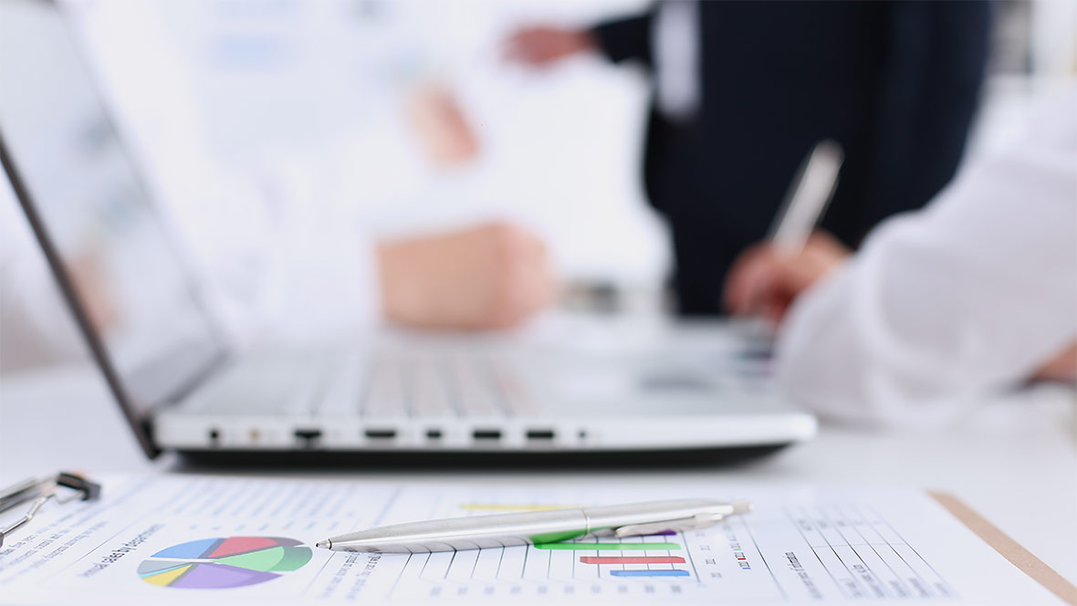 Ein Laptop und der Ausdruck einer Auswertung auf einem Schreibtisch. Ein Laptop und der Ausdruck einer Auswertung auf einem Schreibtisch.