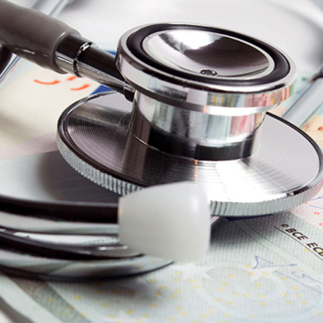 Ein Stethoskop und Geldscheine auf einem Tisch. Ein Stethoskop und Geldscheine auf einem Tisch.