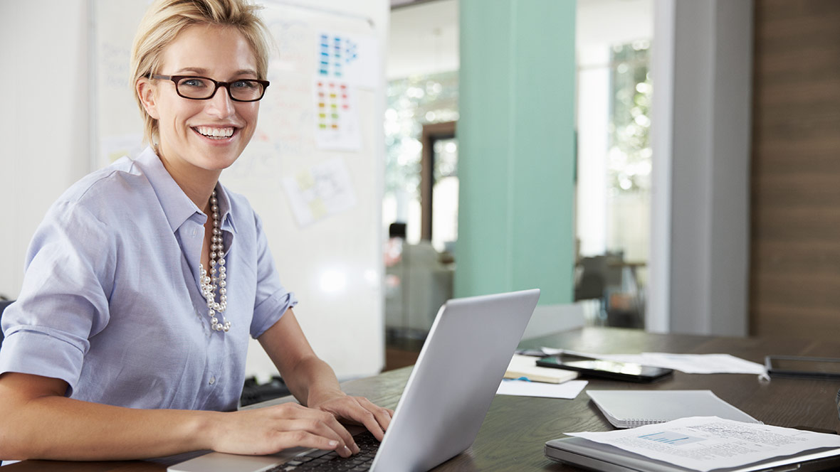 Eine Frau an einem Laptop am Schreibtisch Eine Frau an einem Laptop am Schreibtisch