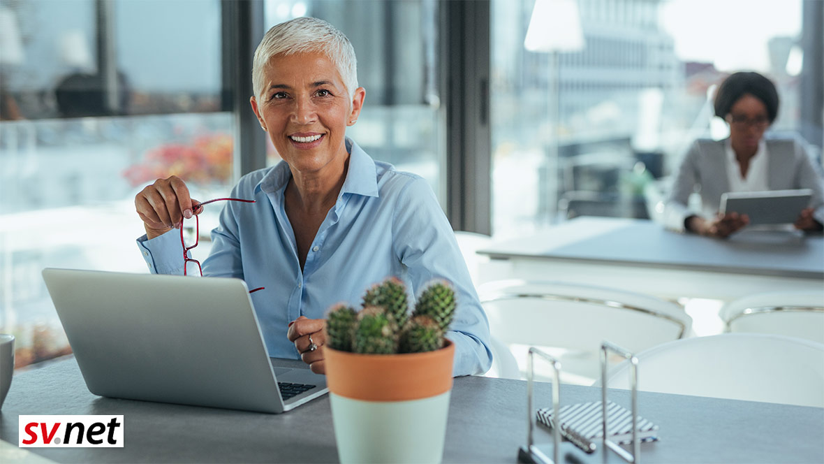 Eine Frau arbeitet in einem Büro an einem Laptop. Eine Frau arbeitet in einem Büro an einem Laptop.