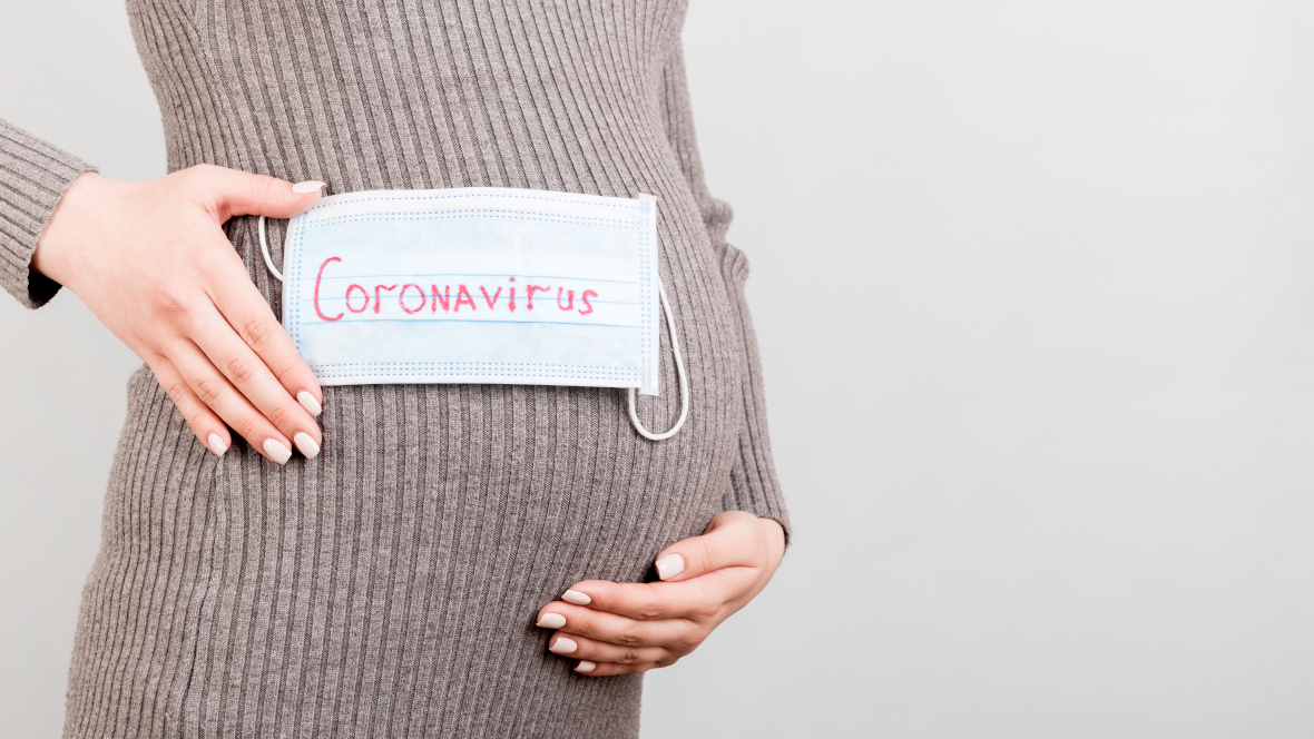 Medizinische Maske mit der Aufschrift Coronavirus auf dem Bauch einer Schwangeren Medizinische Maske mit der Aufschrift Coronavirus auf dem Bauch einer Schwangeren