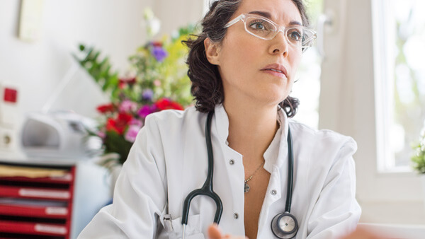 Eine Ärztin sitzt in einem Praxiszimmer. Eine Ärztin sitzt in einem Praxiszimmer.