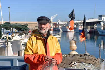 A seaman at a haven with a fishing net in his hands